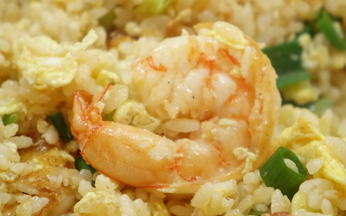 Shrimp fried rice with peas and egg in a pan
