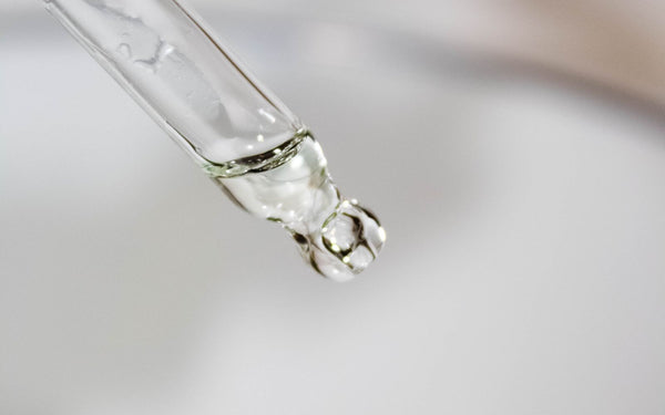 Macro shot of a liquid drop suspended on a pipette, highlighting precision