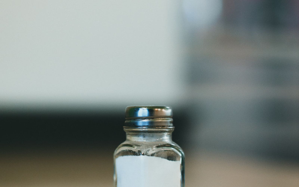 Close-up of a salt shaker on a wooden surface with a blurred background