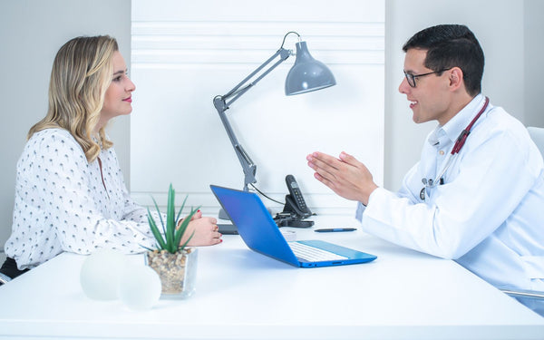 A doctor conducts a patient consultation in a bright, modern medical office