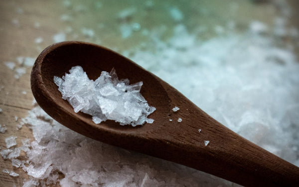 Detailed view of coarse sea salt crystals on a wooden spoon