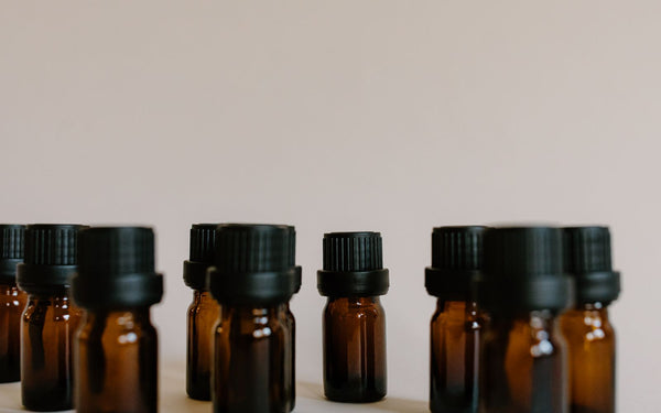 Close-up of amber glass dropper bottles arranged on a white surface