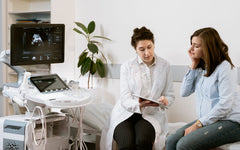 A pregnant woman consults with a healthcare professional in a medical clinic