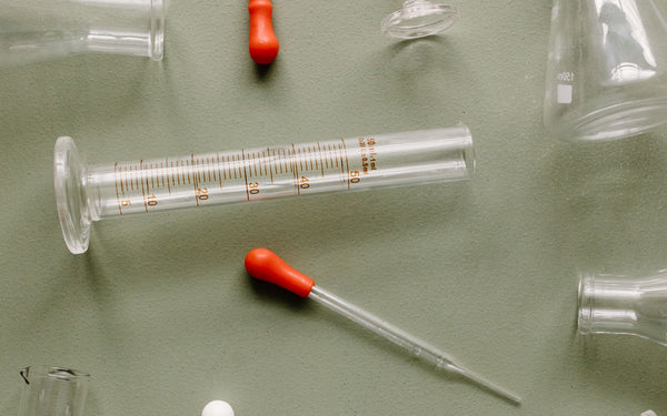 Close-up of a graduated dropper and cylinder used to measure liquid in a laboratory setting