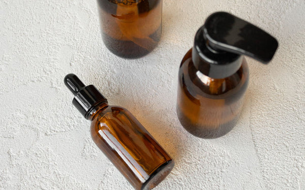 Amber glass dropper bottles arranged on a textured surface for comparison