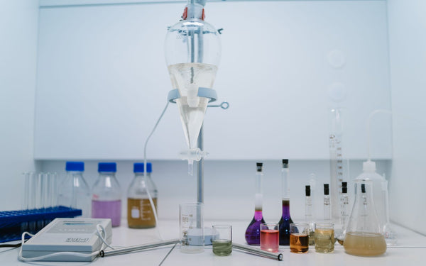 A well-equipped laboratory shelf showcasing various glassware and colorful chemical liquids